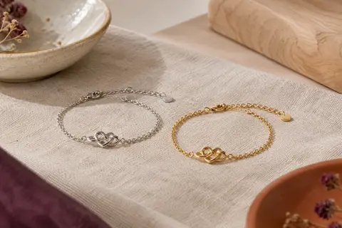 Deux bracelets assortis, l’un argenté et l’autre doré, avec un motif de nœud d’amour