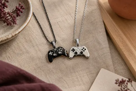 Deux colliers assortis argentés et noirs avec des pendentifs en forme de manettes de jeu
